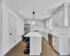 Kitchen featuring a breakfast bar area, a kitchen island, dark wood-style flooring, a sink, and appliances with stainless steel finishes