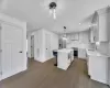 Kitchen with wood finished floors, a breakfast bar area, stainless steel appliances, and a sink