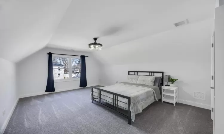 Carpeted bedroom featuring visible vents and baseboards