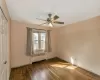 Spare room with radiator, wood-type flooring, baseboards, and a ceiling fan