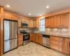 Kitchen featuring light stone counters, stainless steel appliances, a kitchen island, a sink, and backsplash