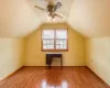 Carpeted bedroom with a ceiling fan, lofted ceiling, and baseboards