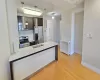 Kitchen with light wood-style flooring, stainless steel appliances, a peninsula, a sink, and baseboards