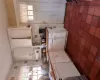 Kitchen with dark tile patterned floors, dishwasher, decorative backsplash, white cabinetry, and a sink