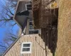 Property entrance featuring a lawn, roof with shingles, and a chimney