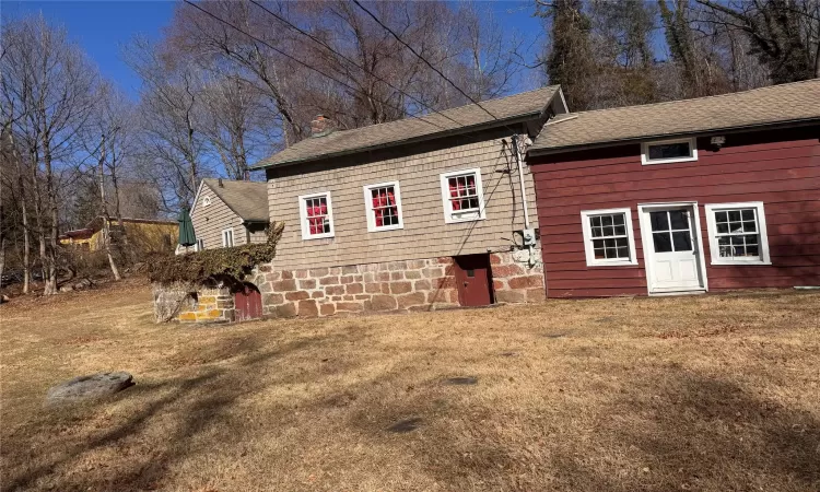 side of house with a lawn and roof with shingles