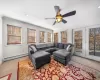 Carpeted living room with crown molding, a ceiling fan, and a baseboard radiator