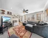 Living room featuring crown molding, baseboard heating, and ceiling fan