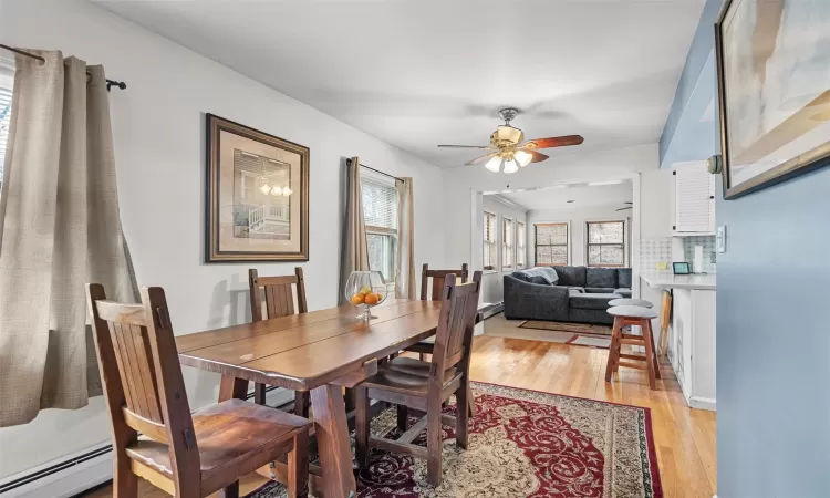 Dining space featuring light wood-type flooring, a baseboard heating unit, and ceiling fan