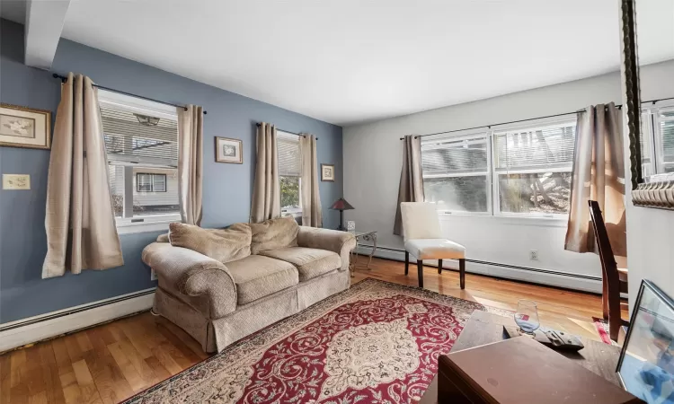 Living room with baseboard heating and wood finished floors