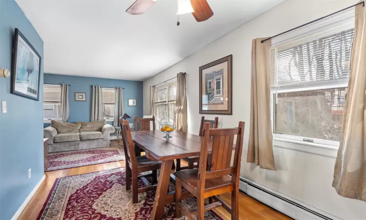 Dining room with baseboard heating, ceiling fan, and wood finished floors