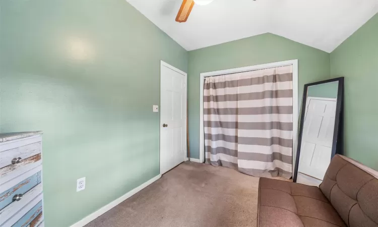 Unfurnished room with baseboards, carpet, a ceiling fan, and vaulted ceiling