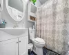 Full bathroom with tile patterned floors, toilet, a shower with shower curtain, and vanity