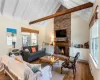 Living area featuring beam ceiling, baseboard heating, a fireplace, and hardwood / wood-style floors