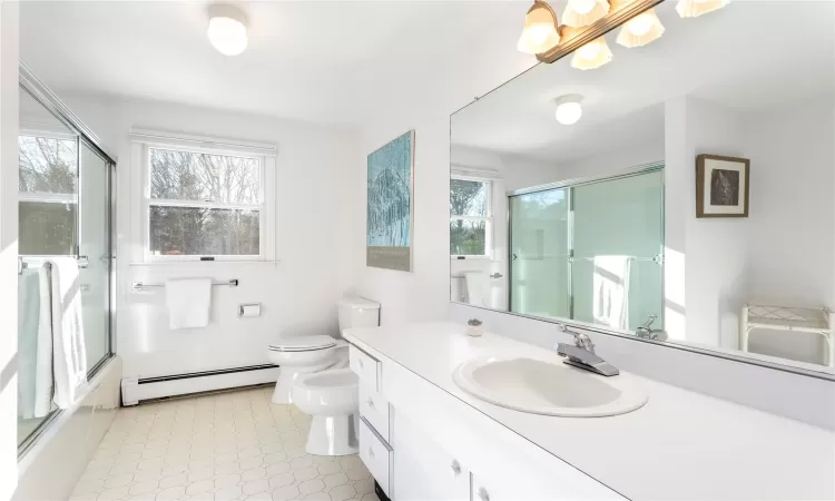 Bathroom featuring vanity, toilet, a bidet, and baseboard heating