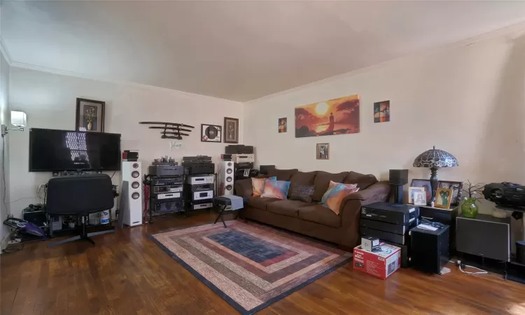 Living room with hardwood / wood-style floors and crown molding