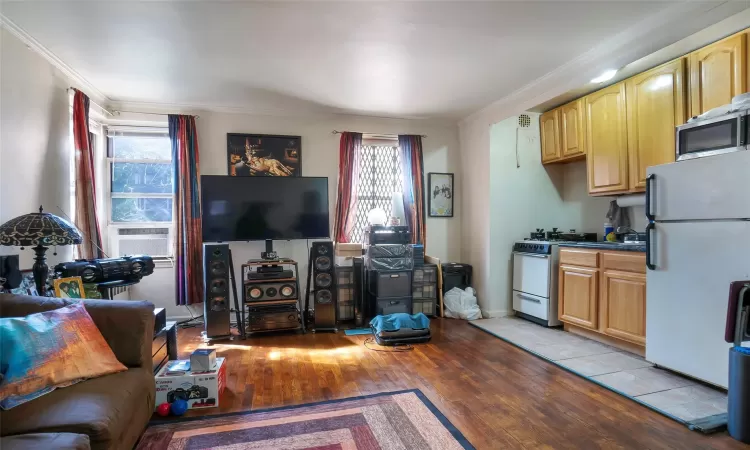 Living area featuring a wealth of natural light, light wood-style floors, and ornamental molding