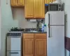 Kitchen with a sink, white appliances, and dark countertops