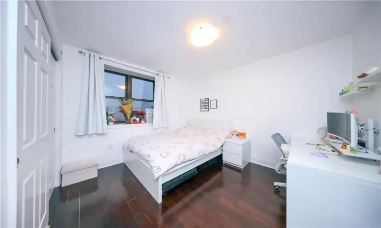 Bedroom with a closet, baseboards, and wood finished floors