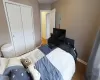 Bedroom featuring electric panel, a closet, baseboards, and wood finished floors