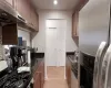 Kitchen featuring dishwashing machine, gas stove, a sink, under cabinet range hood, and stainless steel fridge