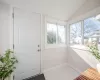 Doorway to outside with baseboards, lofted ceiling, and marble finish floor