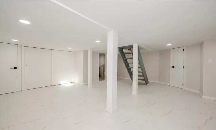 Finished basement featuring stairway, recessed lighting, marble finish floor, and baseboards