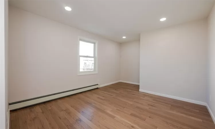 Spare room featuring recessed lighting, light wood-style flooring, baseboards, and a baseboard radiator