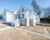 Bungalow-style home with stone siding and fence