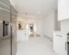 Kitchen featuring recessed lighting, a baseboard heating unit, a peninsula, and stainless steel fridge with ice dispenser