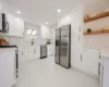 Kitchen with open shelves, a sink, stainless steel appliances, white cabinets, and marble finish floor