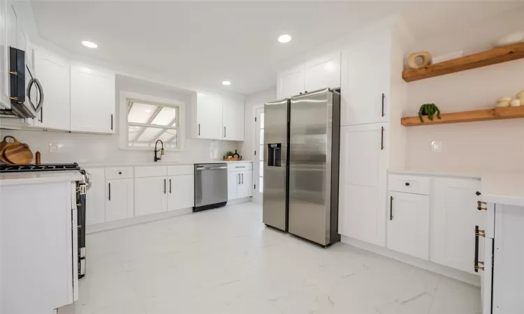 Kitchen with open shelves, a sink, stainless steel appliances, white cabinets, and marble finish floor