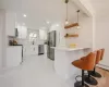 Kitchen with marble finish floor, a sink, stainless steel appliances, a peninsula, and crown molding