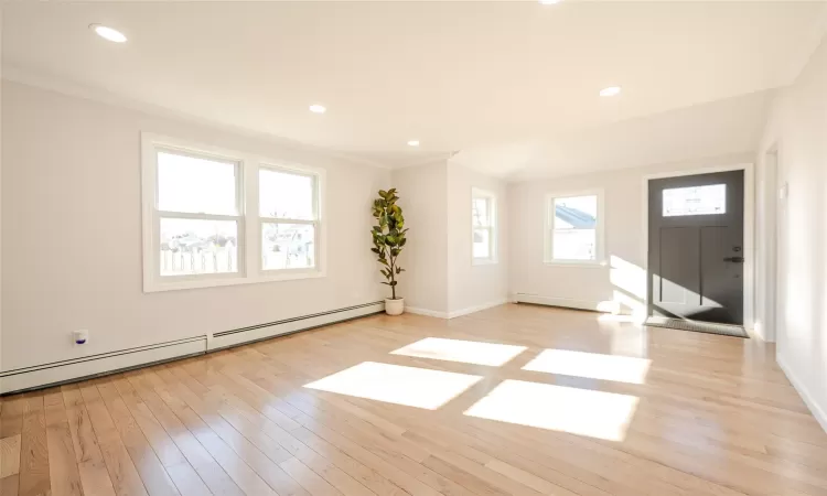 Foyer featuring ornamental molding, recessed lighting, light wood finished floors, baseboards, and baseboard heating