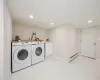 Laundry room with recessed lighting, marble finish floor, washing machine and dryer, and a baseboard heating unit