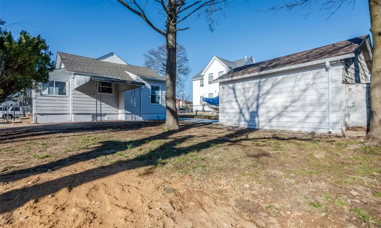 Back of property featuring a shingled roof