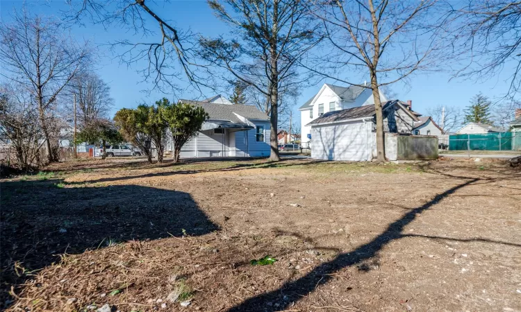 View of yard with an outbuilding, a storage unit, and fence