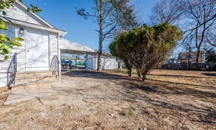 View of yard featuring an outbuilding and fence