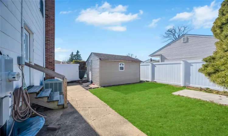 View of yard featuring a patio, a storage shed, an outdoor structure, and fence