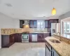 Kitchen with visible vents, appliances with stainless steel finishes, wall chimney range hood, and a sink