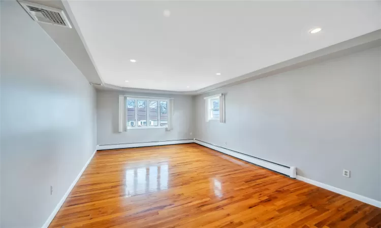 Unfurnished room featuring visible vents, baseboards, baseboard heating, recessed lighting, and wood finished floors