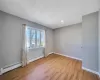 Unfurnished room with a baseboard heating unit, wood finished floors, and baseboards