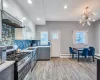 Kitchen with gray cabinets, a sink, light countertops, appliances with stainless steel finishes, and tasteful backsplash