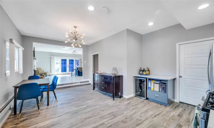 Kitchen featuring beverage cooler, recessed lighting, light wood-style flooring, and a baseboard heating unit