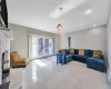 Living room featuring light tile patterned floors, french doors, baseboard heating, and recessed lighting