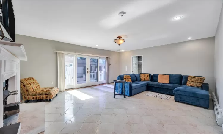 Living room featuring light tile patterned floors, french doors, baseboard heating, and recessed lighting