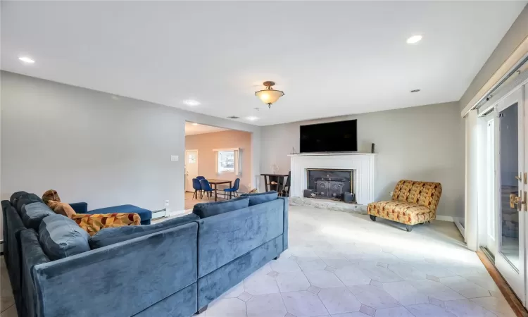 Living room featuring a baseboard heating unit, recessed lighting, and baseboards