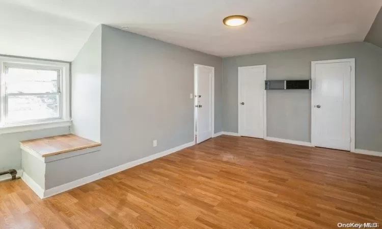 Additional living space with light wood-type flooring and baseboards