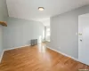 Spare room with vaulted ceiling, radiator, light wood-style floors, and baseboards