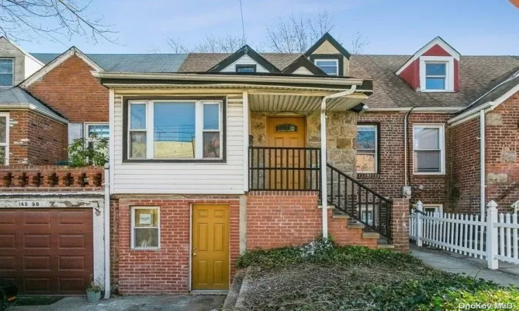 Multi unit property featuring brick siding, a garage, and fence